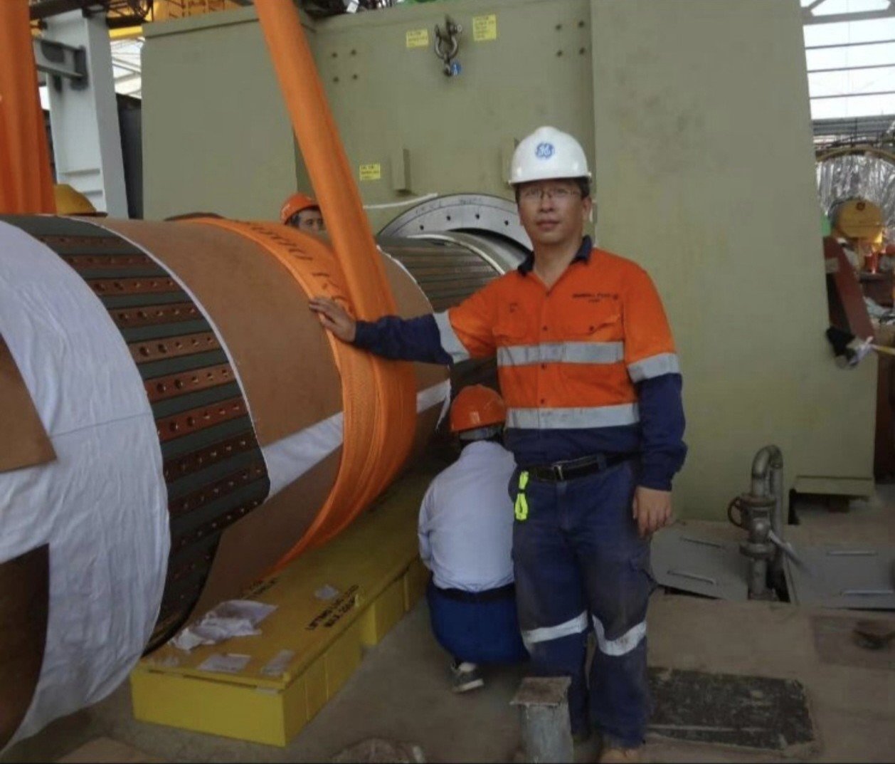 Chen Li beside a generator rotor at a power station